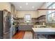 Spacious kitchen with grey cabinets, open shelves, stainless steel appliances, and brick accent wall at 516 N Bloodworth St, Raleigh, NC 27604