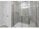 Modern bathroom showcasing a glass-enclosed shower with gray tiling and sleek fixtures at 517 Providence Springs Ln, Fuquay Varina, NC 27526
