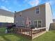 Spacious backyard with a wooden deck, grill, well-maintained lawn, and privacy fencing at 5321 Carnelian Dr, Raleigh, NC 27610