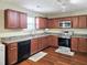 Well-lit kitchen features brown cabinets, stainless steel appliances, and modern countertops at 5321 Carnelian Dr, Raleigh, NC 27610