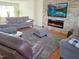 Cozy living room featuring a stone accent wall with a modern fireplace and a mounted television at 5321 Carnelian Dr, Raleigh, NC 27610