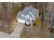 Aerial view of a charming two-story home with a well-manicured lawn, deck and mature trees at 5806 Whispering Meadow Ln, Durham, NC 27712