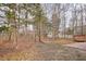 Spacious backyard featuring a wooden deck and brick patio of a lovely home surrounded by trees at 5806 Whispering Meadow Ln, Durham, NC 27712