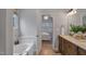 Bathroom featuring a double sink vanity with marble countertop, shower, and a soaking tub at 5806 Whispering Meadow Ln, Durham, NC 27712