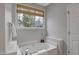 Bathroom featuring a soaking tub with a large window at 5806 Whispering Meadow Ln, Durham, NC 27712