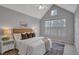This bedroom features a vaulted ceiling, neutral walls, and large window with shutter-style blinds at 5806 Whispering Meadow Ln, Durham, NC 27712