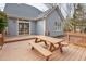 A lovely home exterior featuring a spacious wooden deck with a picnic table and sliding glass doors at 5806 Whispering Meadow Ln, Durham, NC 27712