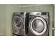This laundry room includes a modern washer and dryer, plus shelving for storage at 5806 Whispering Meadow Ln, Durham, NC 27712