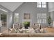 Bright living room features vaulted ceilings, hardwood floors, fireplace, and multiple window views to backyard at 5806 Whispering Meadow Ln, Durham, NC 27712