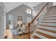 Living room featuring vaulted ceilings, a ceiling fan, a fireplace, stairs and neutral walls at 5806 Whispering Meadow Ln, Durham, NC 27712
