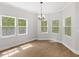 Elegant dining room with hardwood floors, a chandelier, and bright windows overlooking the backyard at 5945 Four Townes Ln, Raleigh, NC 27616