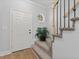 Welcoming entryway features neutral paint, hardwood flooring, and a staircase with carpeted steps at 5945 Four Townes Ln, Raleigh, NC 27616