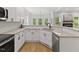 Modern kitchen with white cabinets, granite countertops, stainless steel appliances, and natural light at 5945 Four Townes Ln, Raleigh, NC 27616