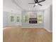 Bright living room with hardwood floors, a modern fireplace, and large windows offering scenic views at 5945 Four Townes Ln, Raleigh, NC 27616
