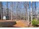 Wooded backyard with storage shed, bare trees, and a sloped lawn at 613 Hamecon Place, Cedar Grove, NC 27231