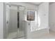 Bright bathroom features walk-in shower, soaker tub, and window at 613 Hamecon Place, Cedar Grove, NC 27231