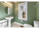 Well-lit bathroom with vanity sink, round mirror, toilet, and window with natural light at 613 Hamecon Place, Cedar Grove, NC 27231