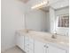 Bathroom featuring double sinks with marble countertop vanity and large mirror at 613 Hamecon Place, Cedar Grove, NC 27231