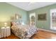 Cozy bedroom with bright green walls, wood floors, and sun-filled windows at 613 Hamecon Place, Cedar Grove, NC 27231