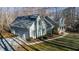 View of the light green home, with attached garage, driveway, manicured lawn, and mature trees at 613 Hamecon Place, Cedar Grove, NC 27231
