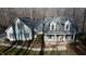 Aerial view of the light green home with a front porch, mature landscaping, and long driveway at 613 Hamecon Place, Cedar Grove, NC 27231