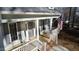 Close up of inviting front porch with rocking chairs and charming columns on a sunny day at 613 Hamecon Place, Cedar Grove, NC 27231