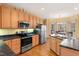 Open kitchen features stainless appliances, light wood cabinets, and an eat-in breakfast nook with wooded views at 613 Hamecon Place, Cedar Grove, NC 27231