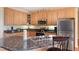 Bright kitchen features stainless appliances, light wood cabinets, and a large island with breakfast bar at 613 Hamecon Place, Cedar Grove, NC 27231