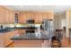 Kitchen with maple cabinets, stainless steel appliances, island with bar seating, and hardwood floors at 613 Hamecon Place, Cedar Grove, NC 27231