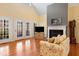 Bright and sunny living room featuring a fireplace, French doors, and hardwood floors at 613 Hamecon Place, Cedar Grove, NC 27231