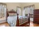 Spacious main bedroom with wood floors, large windows with wood views, and a decorative metal bed frame at 613 Hamecon Place, Cedar Grove, NC 27231