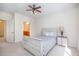 Serene bedroom with whitewashed furnishings, ceiling fan, open door to en-suite bathroom, and carpet at 622 Ives Ct # 622, Chapel Hill, NC 27514