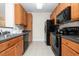 Efficient kitchen with wooden cabinets, black appliances, countertops, and tiled flooring at 622 Ives Ct # 622, Chapel Hill, NC 27514