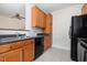 Functional kitchen with wood cabinets, black appliances, ample counter space, and tiled floor at 622 Ives Ct # 622, Chapel Hill, NC 27514