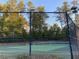 Community tennis court surrounded by a fence and lush greenery at 622 Ives Ct # 622, Chapel Hill, NC 27514