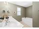 Bathroom showcasing double sinks, a large mirror, and a soaking tub under a window at 622 Village Lake Drive, Mebane, NC 27302