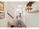 Hallway view with wood floors, coat rack, wall art, and staircase leading to upper level at 622 Village Lake Drive, Mebane, NC 27302