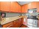Well-equipped kitchen with wooden cabinets, granite countertops, and stainless steel appliances at 622 Village Lake Drive, Mebane, NC 27302
