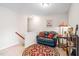 Comfortable loft area with a dark loveseat, decorative rug, and ample lighting at 622 Village Lake Drive, Mebane, NC 27302