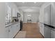 Modern kitchen open to dining area featuring white cabinets, stainless appliances, and granite countertops at 703 Vance St, Henderson, NC 27536