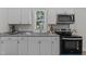 Kitchen with modern appliances, white cabinets, granite countertop, and natural light at 703 Vance St, Henderson, NC 27536