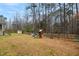 A large back yard with privacy fencing features playground equipment and a storage shed at 7100 Winter Pond Way, Fuquay Varina, NC 27526