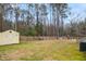 A spacious fenced back yard features a shed and playground equipment on a mostly dormant lawn at 7100 Winter Pond Way, Fuquay Varina, NC 27526