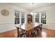 Dining room featuring a large wooden table, seating for eight, hardwood floors, and bright windows at 7100 Winter Pond Way, Fuquay Varina, NC 27526