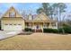 Charming two-story yellow home with a welcoming front porch, landscaped yard, and attached two-car garage at 7100 Winter Pond Way, Fuquay Varina, NC 27526