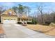 Inviting two-story yellow home showcasing a spacious driveway, landscaped yard, and attached two-car garage at 7100 Winter Pond Way, Fuquay Varina, NC 27526