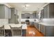 Modern kitchen with gray cabinets, stainless steel appliances, quartz countertops, and hardwood floors at 7100 Winter Pond Way, Fuquay Varina, NC 27526