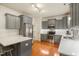 Modern kitchen with gray cabinets, stainless steel appliances, quartz countertops, and hardwood floors at 7100 Winter Pond Way, Fuquay Varina, NC 27526