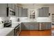 Beautiful kitchen with gray cabinets, stainless steel appliances, quartz countertops, and hardwood floors at 7100 Winter Pond Way, Fuquay Varina, NC 27526