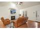 Bright living room featuring a fireplace, high ceilings, hardwood floors, and comfortable leather seating at 7100 Winter Pond Way, Fuquay Varina, NC 27526
